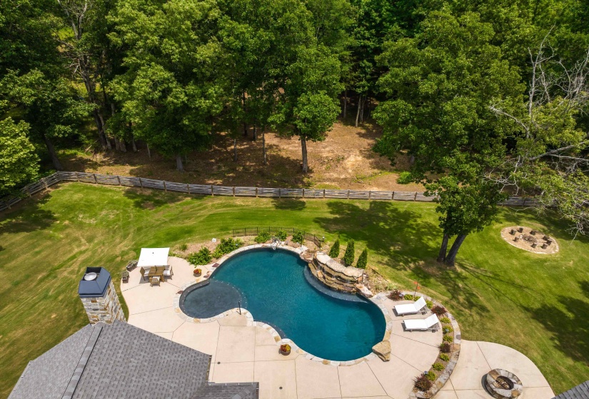 Freeform swimming pool with a rock waterfall feature and integrated spa