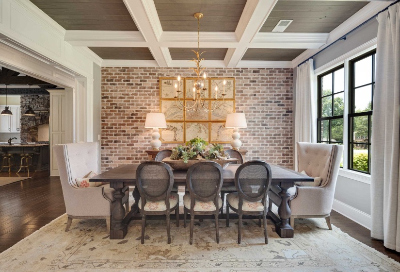 Formal dining area featuring an exposed brick accent wall, coffered ceiling with wood-finish panels, and dark wood-finish flooring