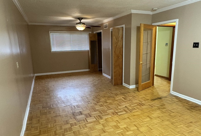 Unfurnished bedroom with a textured ceiling, crown molding, and a ceiling fan