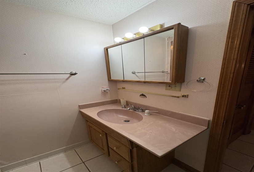 Bathroom featuring light tile patterned floors, vanity, and a textured ceiling