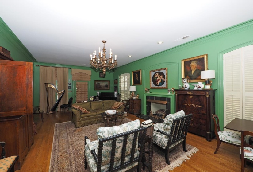 Living room featuring ornamental molding, wood finished floors, a tile fireplace, and a chandelier