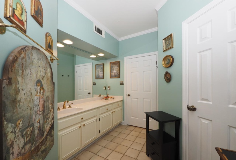 Full bathroom featuring ornamental molding, double vanity, and light tile patterned flooring
