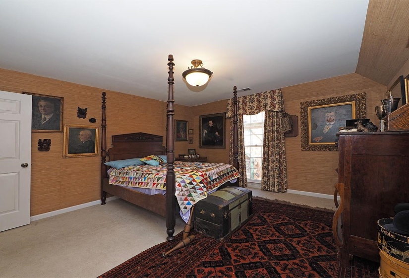 Carpeted bedroom featuring wallpapered walls and baseboards