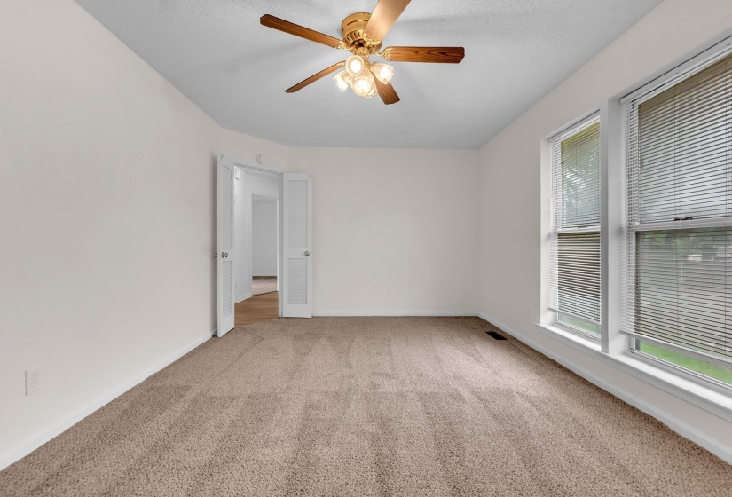 Spacious room featuring neutral carpeting and white walls