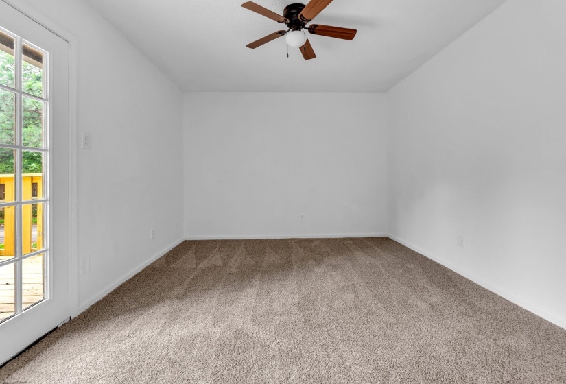 Room featuring neutral carpet flooring, white painted walls, and a ceiling fan with a central light fixture