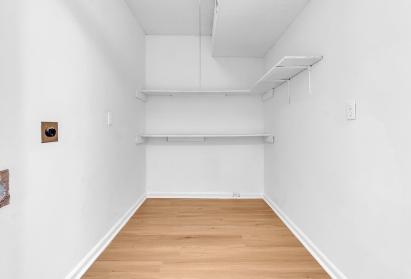 Utility space featuring wood-finish flooring and white baseboards