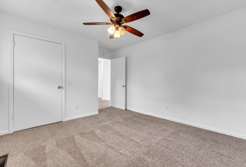 Spacious room featuring neutral carpeting and white walls