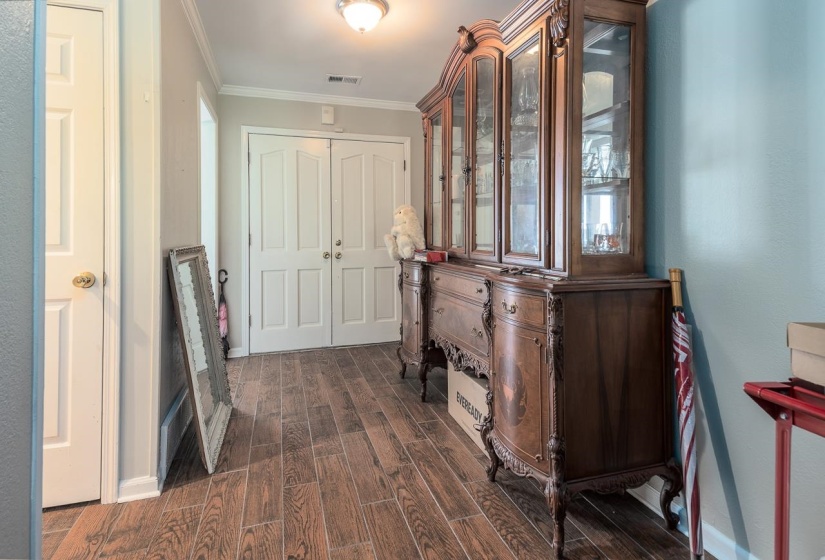 Hall with dark wood-style floors and ornamental molding