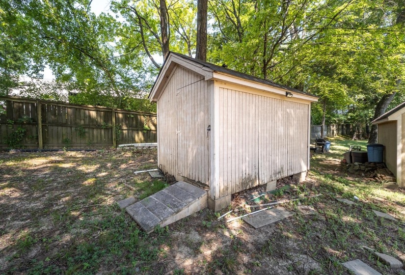 View of shed featuring a fenced backyard and view of scattered trees