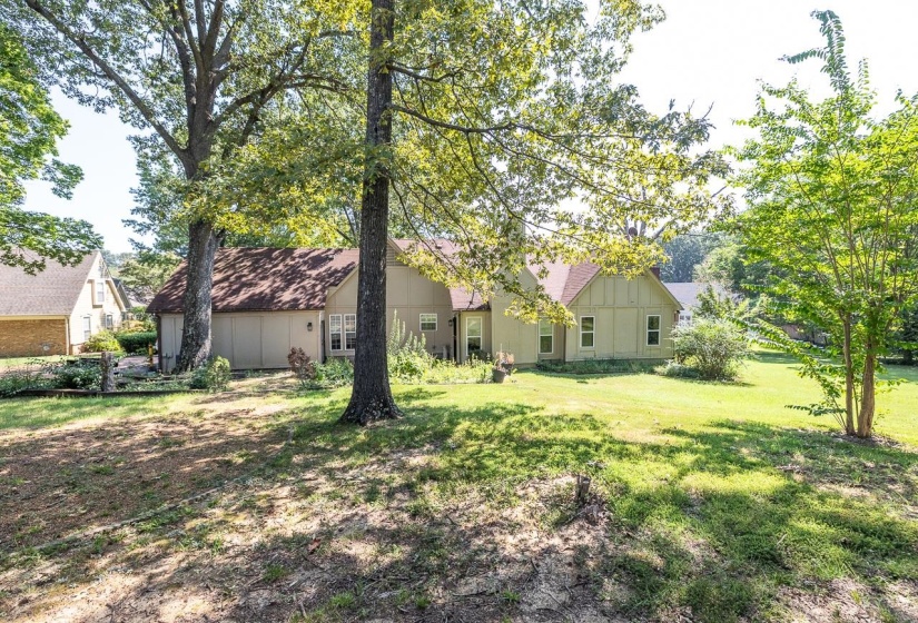 Back of house with board and batten siding and a yard