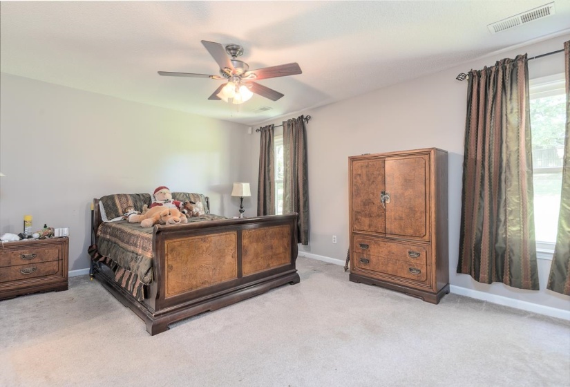 Carpeted bedroom featuring ceiling fan and baseboards