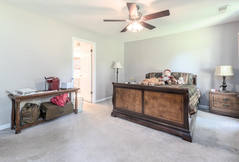 Bedroom with carpet, ceiling fan, and ensuite bath