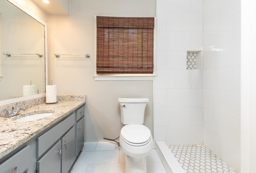Full bathroom with vanity, a stall shower, and light tile patterned flooring
