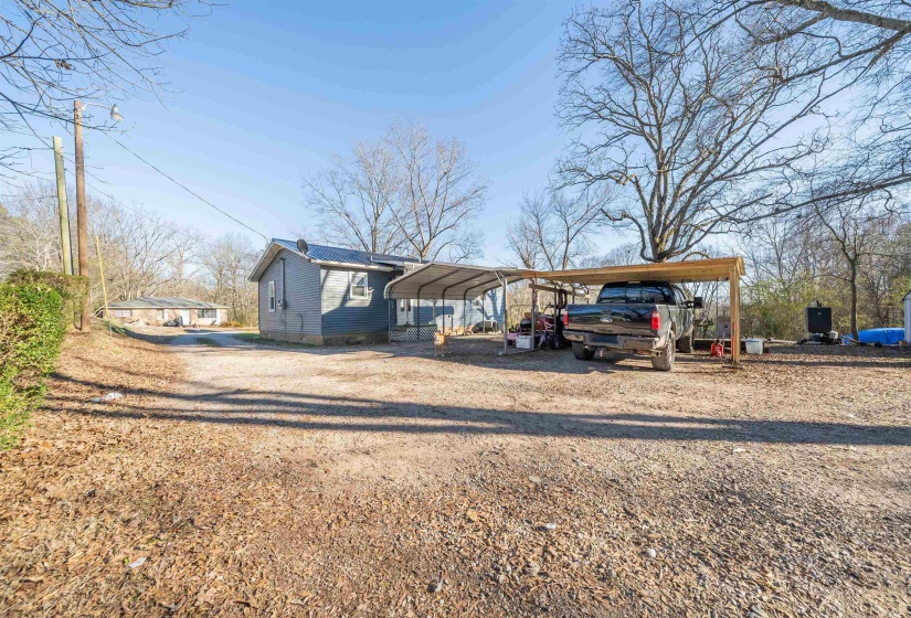View of front of house with driveway and a detached carport