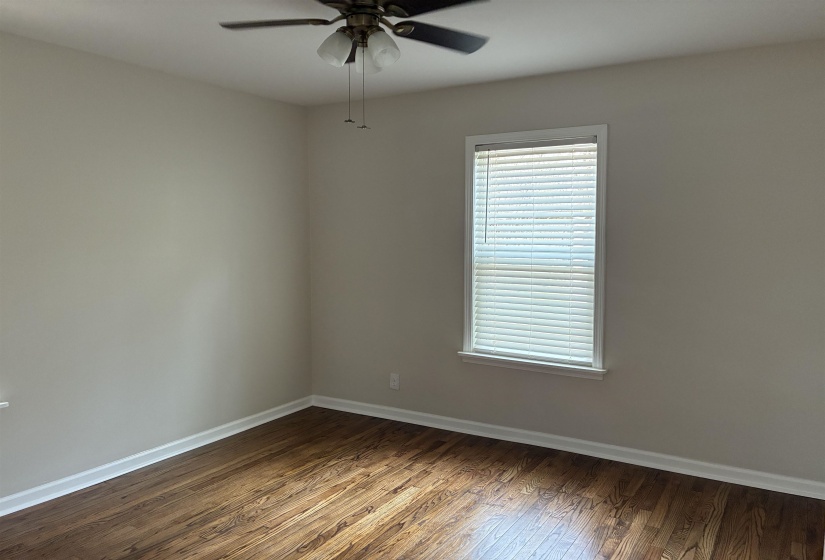 Unfurnished room featuring dark wood finished floors and ceiling fan