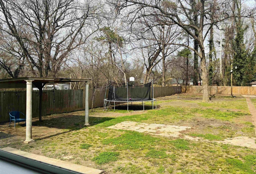 Fenced backyard with a trampoline