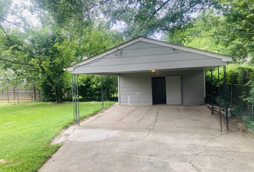 Carport structure with a flat concrete driveway and a gray exterior