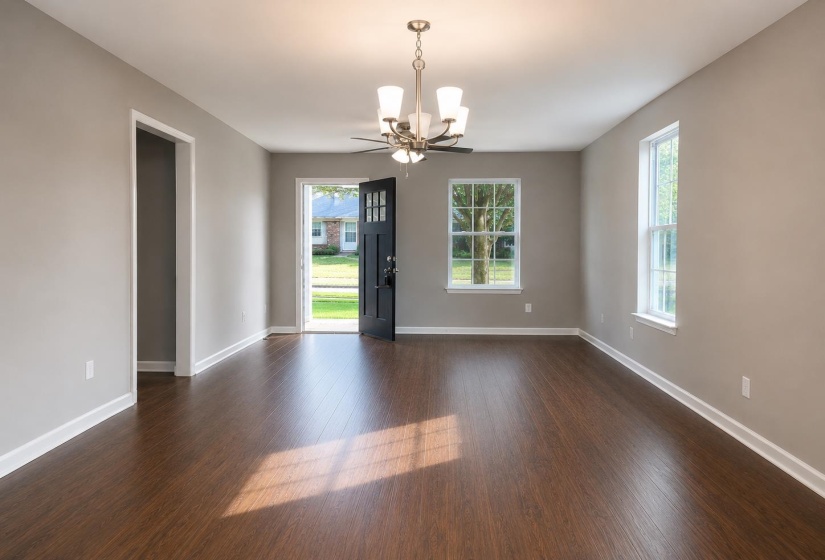 Open concept living space featuring wood-finish flooring, neutral wall tones, and white trim