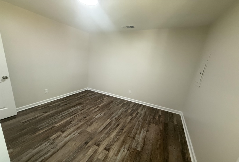 Neutral tone walls with white trim, wood-finish flooring, and a flush-mount ceiling light fixture