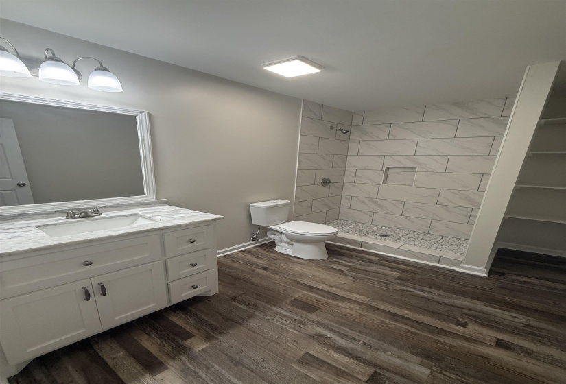 Bathroom featuring a white vanity with a stone-finish countertop, undermount sink, and chrome faucet
