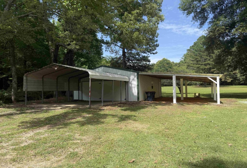 Detached structure featuring multiple covered areas, including an open-sided carport and an additional covered patio space