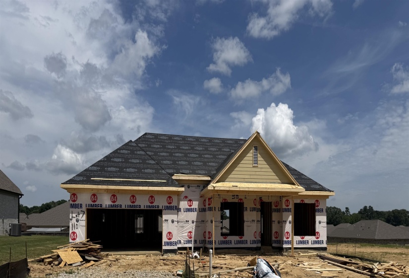 New construction with completed roof shingles, a prominent front gable, and exterior sheathing
