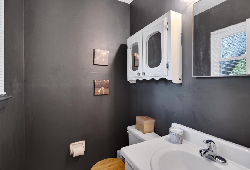 Bathroom featuring a white ceramic sink, chrome faucet, and dark-painted walls