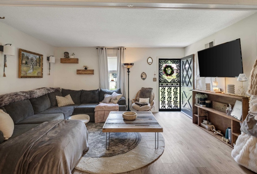 Open-concept living area featuring light wood-finish flooring and white walls