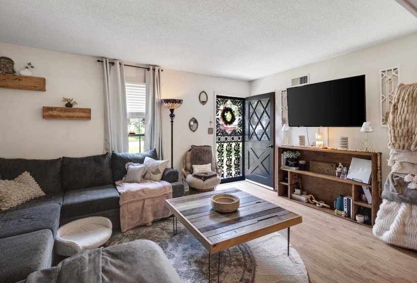 Bright living area featuring wood-finish flooring and white walls