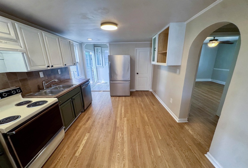 Kitchen featuring wood-finish flooring, white upper cabinetry, and green lower cabinetry