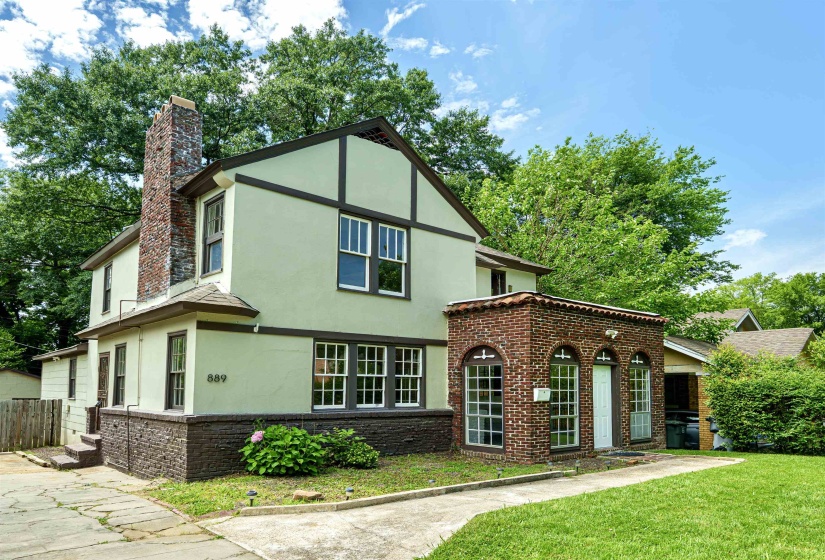 Tudor-style residence featuring a stucco and brick exterior with dark trim accents