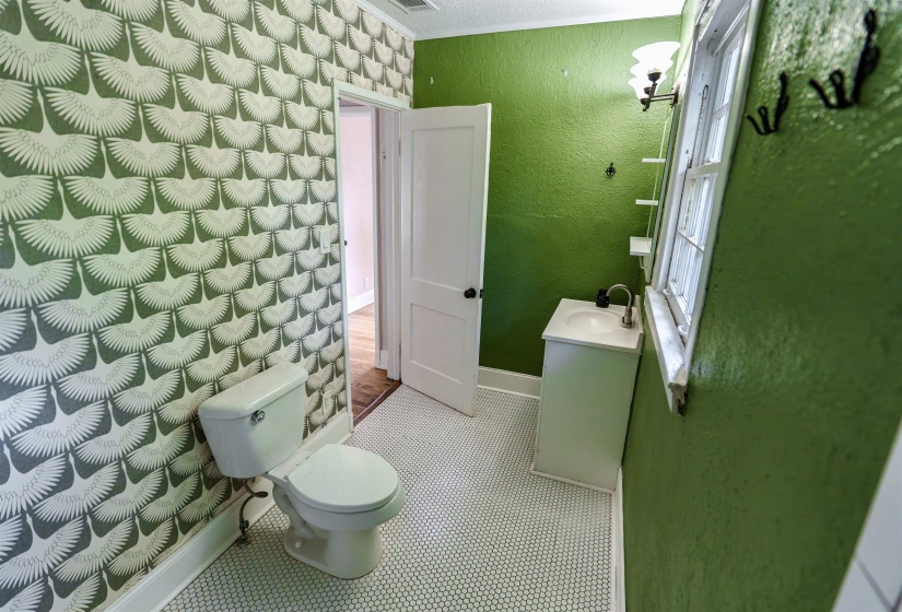 Bathroom with patterned wallpaper and textured green walls