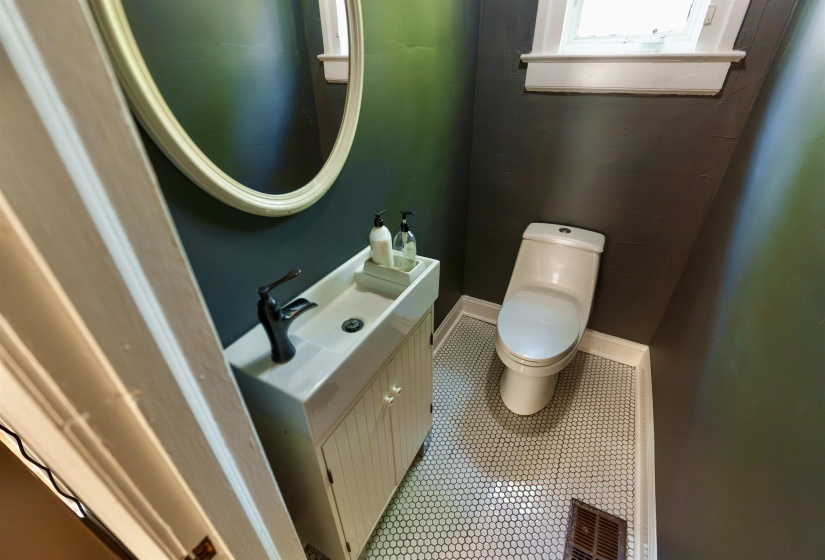 Compact bathroom featuring dark gray walls and honeycomb tile flooring
