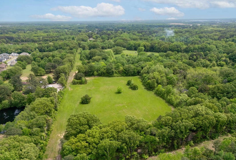 Birds eye view of property featuring a wooded view