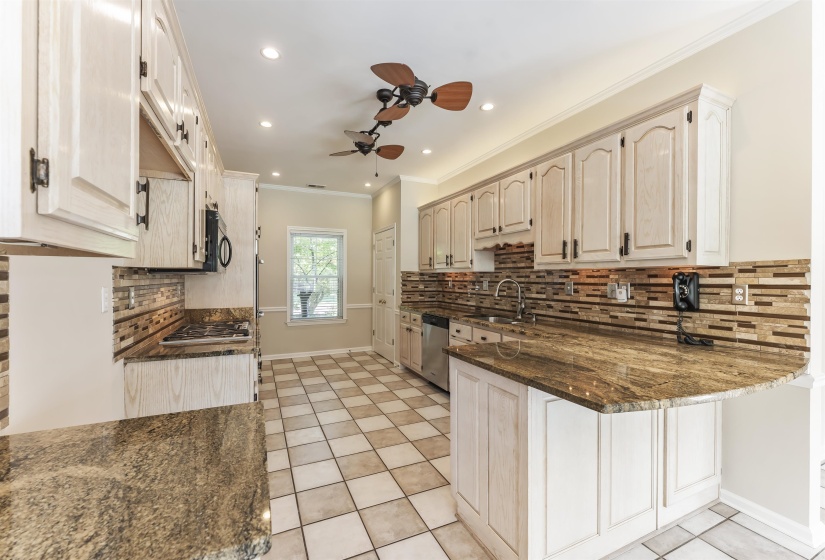 Kitchen featuring ample light-toned cabinetry, granite countertops, a decorative tile backsplash, recessed lighting, and checkerboard floor tiling