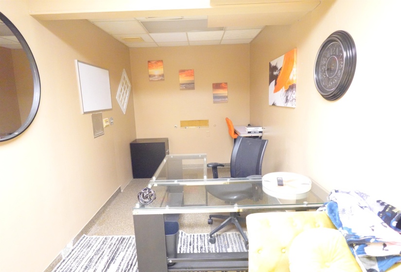 Carpeted home office with a paneled ceiling and baseboards