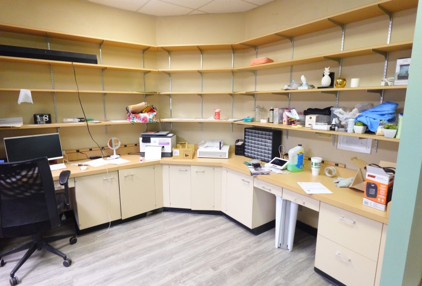 Office space with built in desk and a drop ceiling