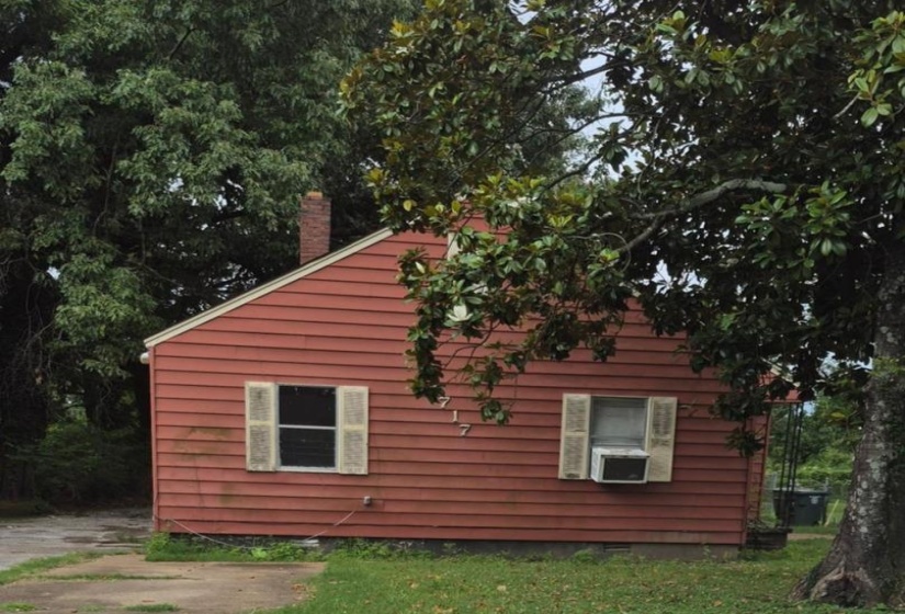 Single-story residence featuring red horizontal siding and a red brick chimney