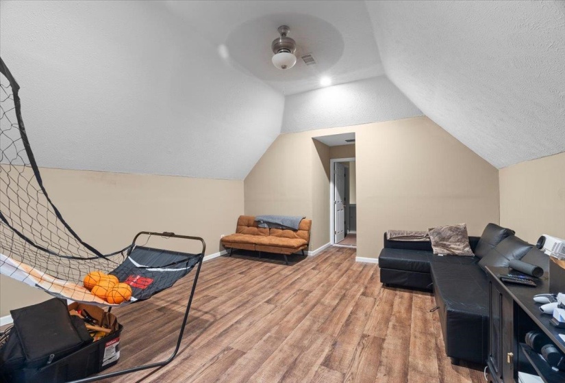 Spacious room with wood-finish flooring and vaulted ceilings