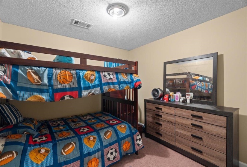 Bedroom featuring neutral wall paint, textured ceiling, and a ceiling-mounted light fixture