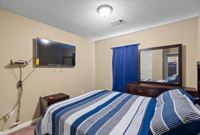 Bedroom featuring neutral wall paint, a ceiling-mounted light fixture, and textured ceiling