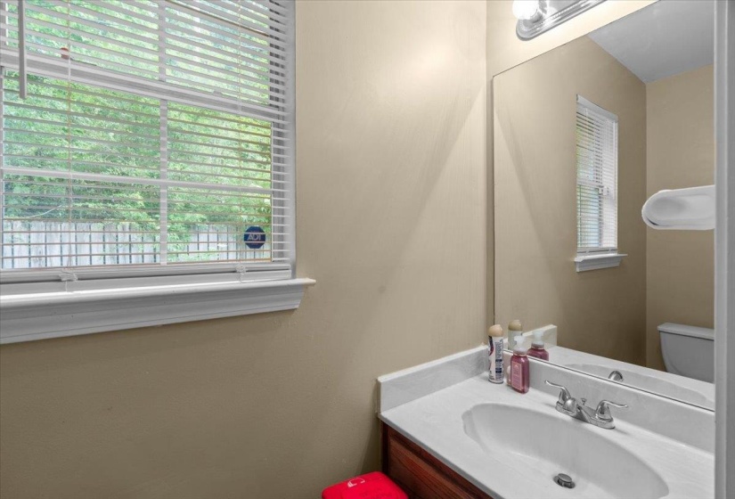 Bathroom vanity with a white countertop and integrated sink, chrome faucet, and a large wall-mounted mirror