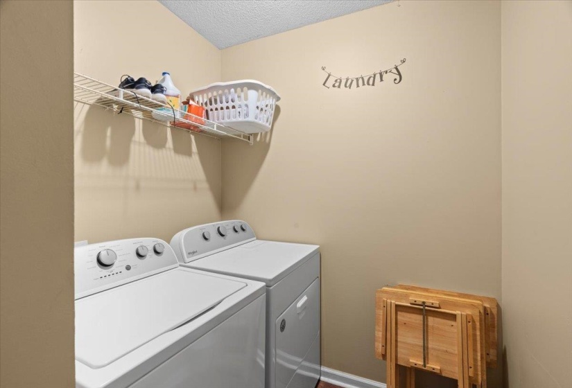 Dedicated laundry area featuring a wire storage shelf