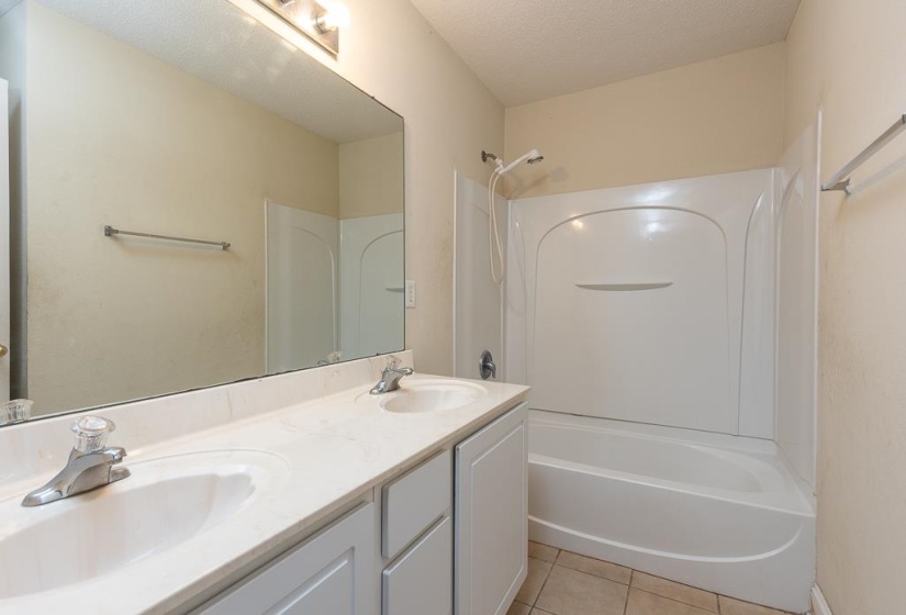 Bathroom featuring a dual-sink vanity with white cabinetry and a white countertop