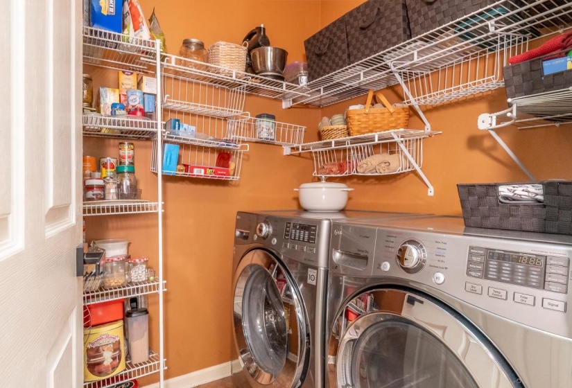 Dedicated pantry & laundry area featuring room for a front-loading washer and dryer, complemented by extensive wire shelving for organization