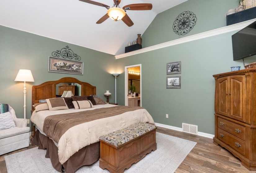 Vaulted ceiling with a wood-finish ceiling fan and integrated lighting