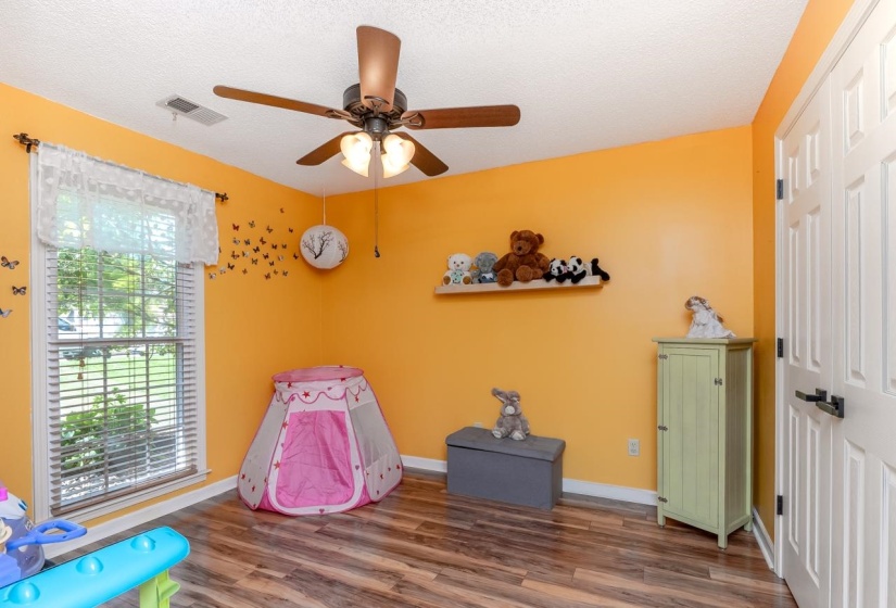 Interior room featuring wood-finish flooring and a ceiling fan with integrated lighting