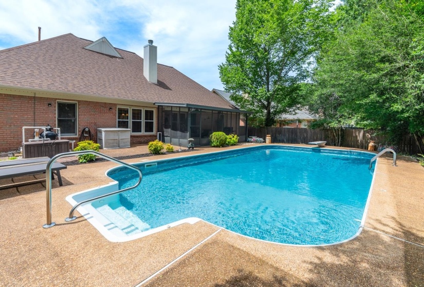 Backyard oasis featuring an in-ground swimming pool with integrated steps, a screened-in porch, brick exterior, and a privacy fence