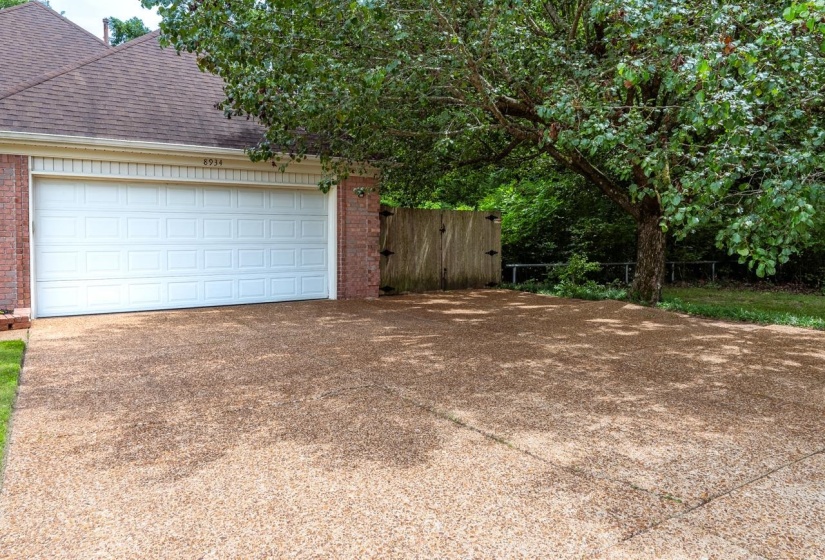 Attached garage with a white paneled door and brick exterior