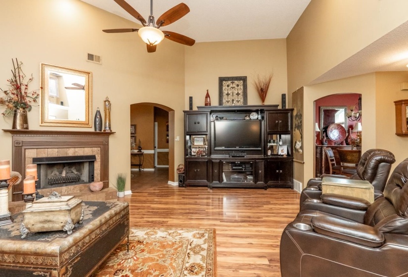 Living area featuring vaulted ceilings, wood-finish flooring, and a ceiling fan